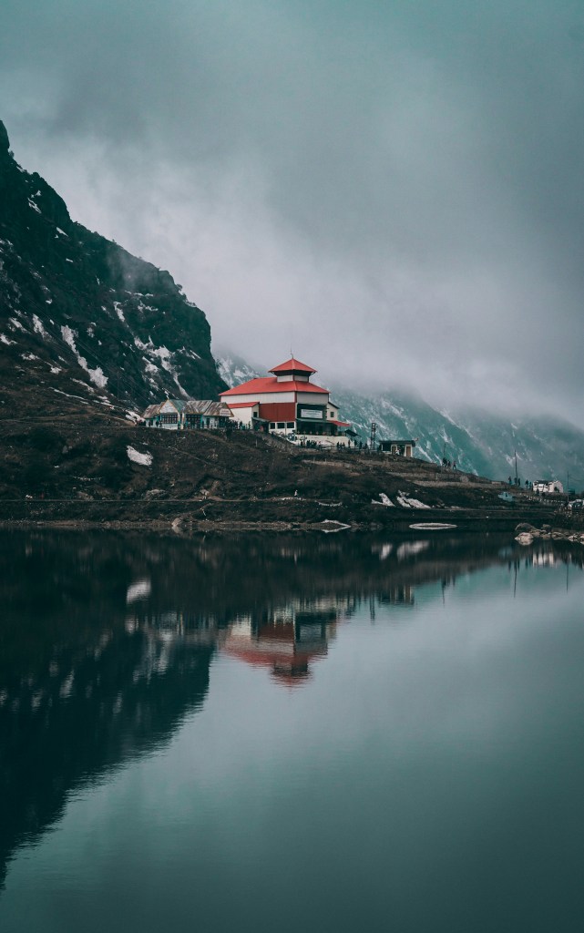 山间湖畔红顶建筑倒影照片