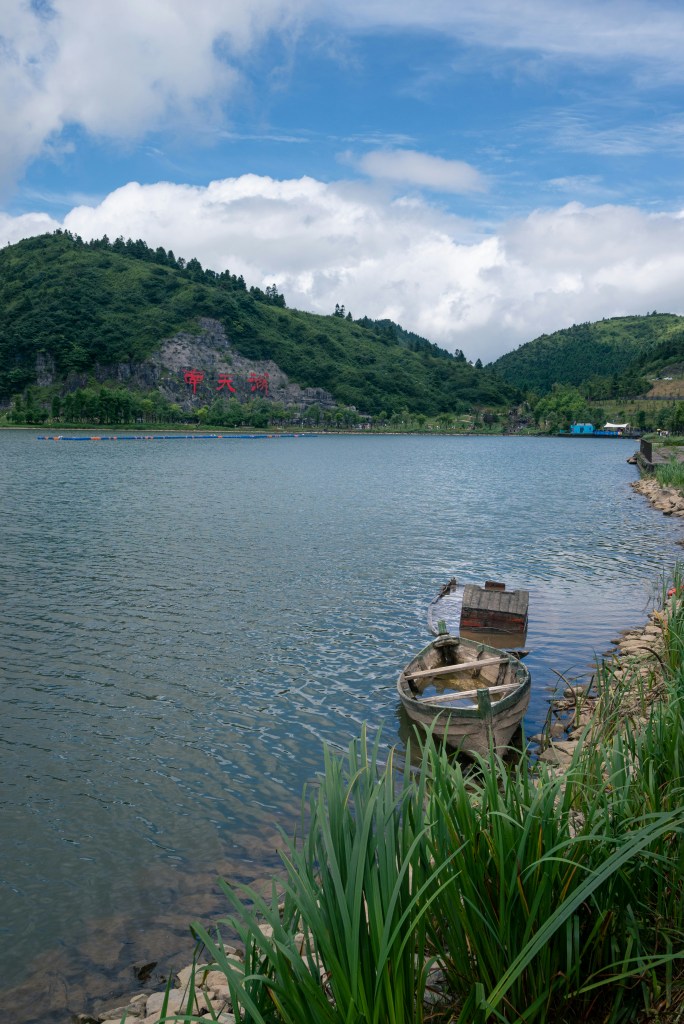 湖畔小船青山蓝天景色照片