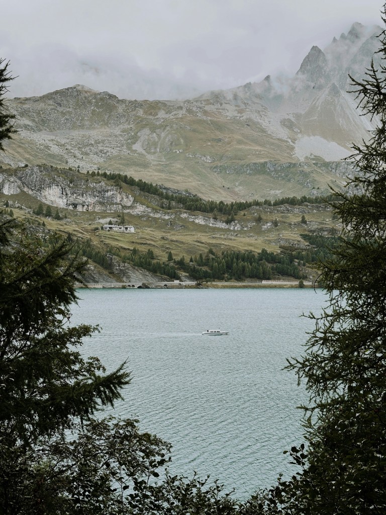 湖畔山峦雾霭游船照片