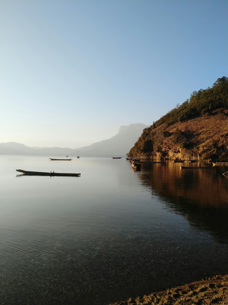 湖畔山崖渔船静景照片
