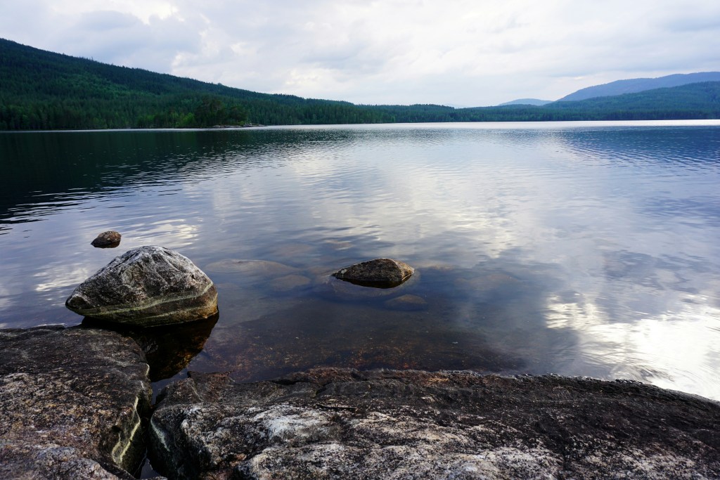 湖畔岩石与远山风景照片