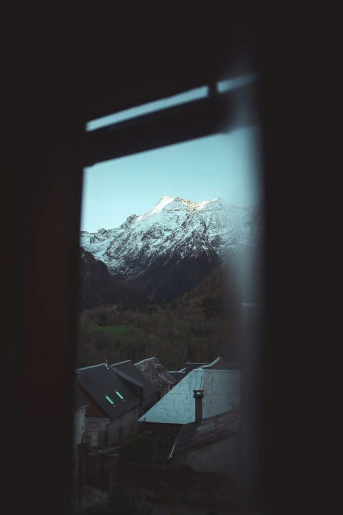 窗前雪山与村落景象照片