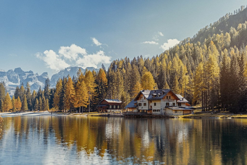湖畔秋景木屋与金黄树林
